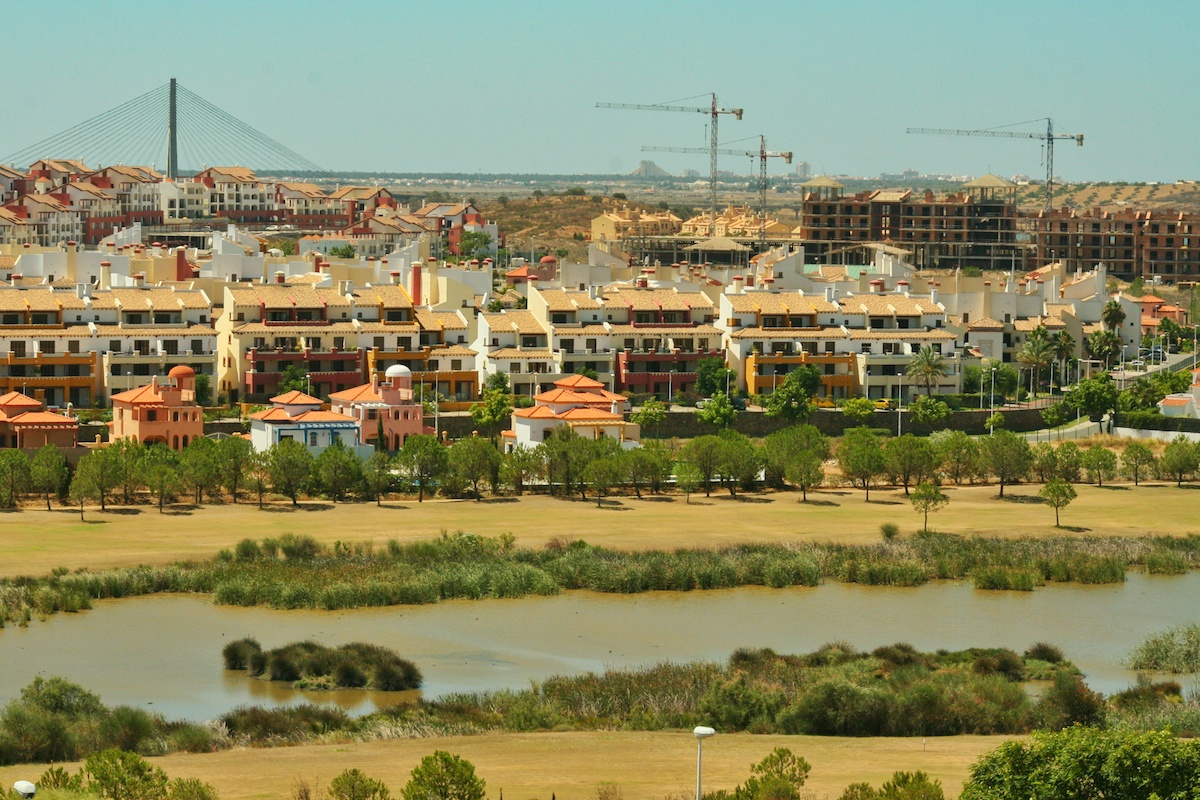 Transformaciones urbanas 1
El proyecto urban&iacute;stico y tur&iacute;stico de Costa Esuri, junto a la desembocadura del r&iacute;o Guadiana, es un enorme complejo residencial, hotelero y de golf que ocupa unas 400 ha (casi duplica la superficie del n&uacute;cleo urbano de Ayamonte). Por su parte, en los municipios del Aljarafe, en el sector occidental de la aglomeraci&oacute;n urbana de Sevilla, existen numerosos casos de promociones residenciales que han quedado paralizadas, lo que se ha dado en llamar urbanizaciones fantasma, como la correspondiente a las fotograf&iacute;as, en Camas. Ambos ejemplos suponen un retrato significativo de los anacolutos territoriales que jalonan las &aacute;reas litorales y la periferia de las grandes ciudades andaluza .